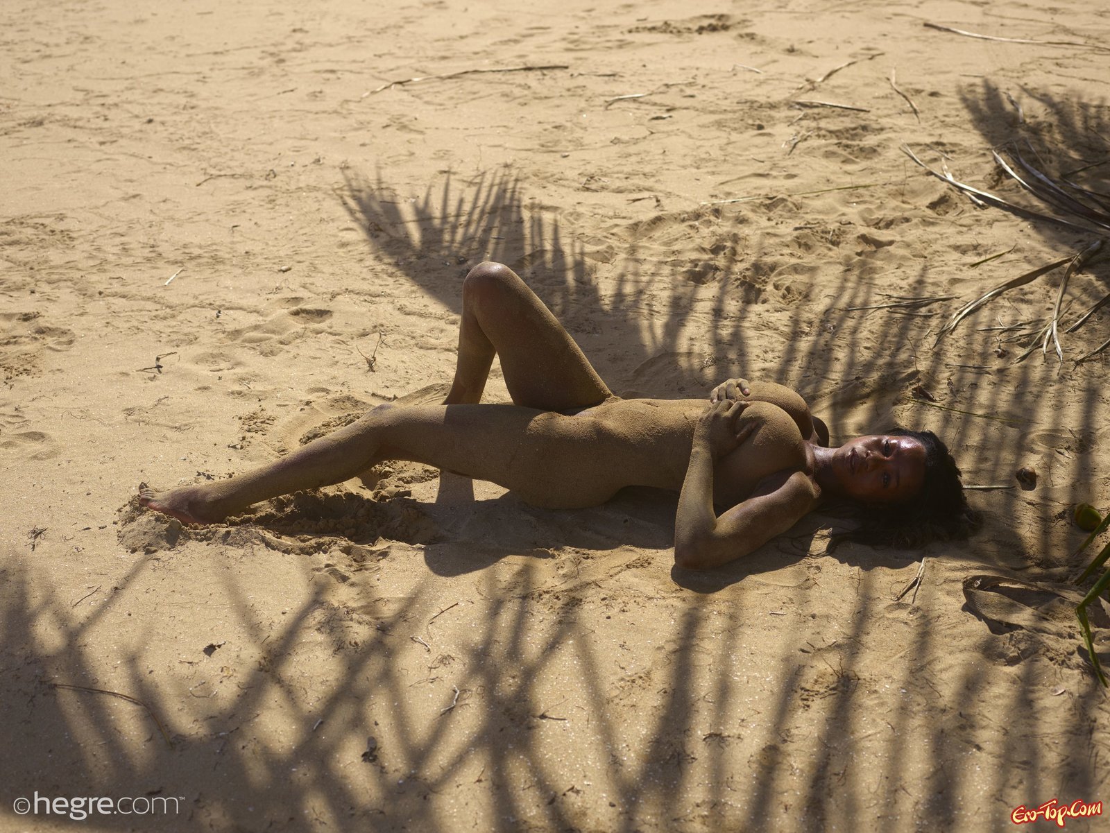 Негритянка с большой грудью валяется на пляже