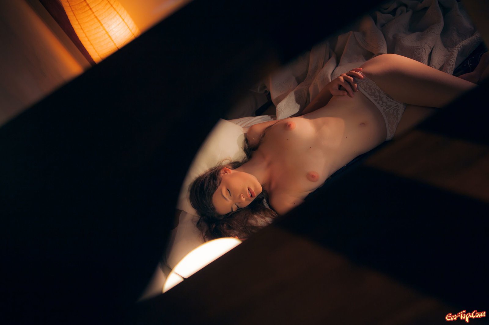 Голая девушка светит грудь сидя в постели