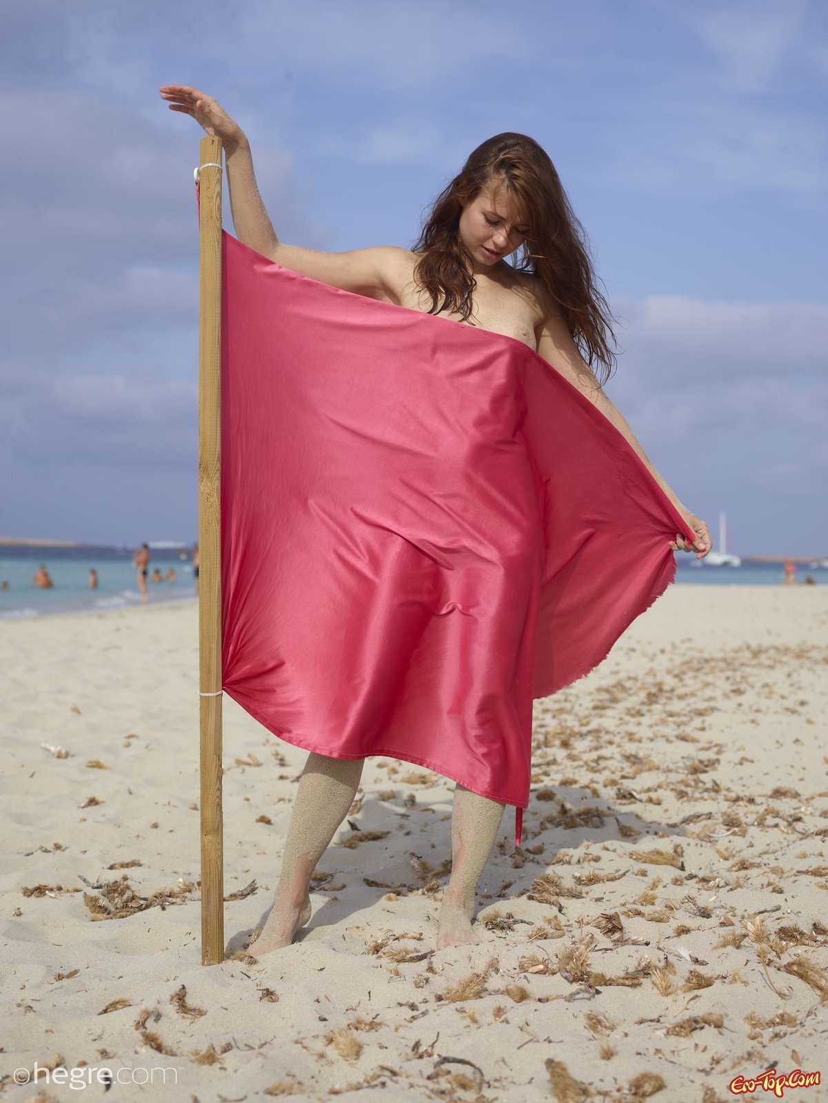 Красива голая девушка в песке на пляже