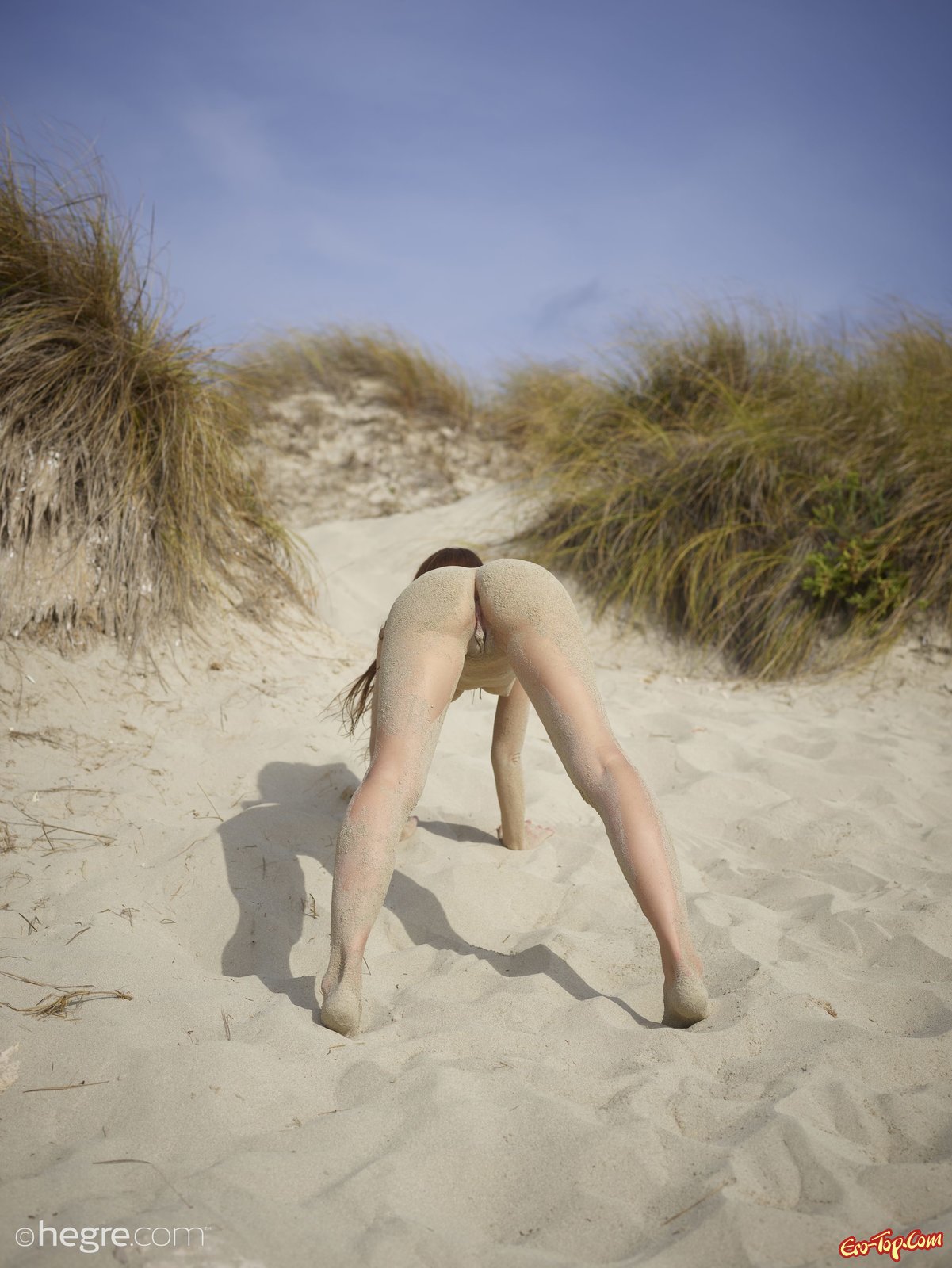 Красива голая девушка в песке на пляже