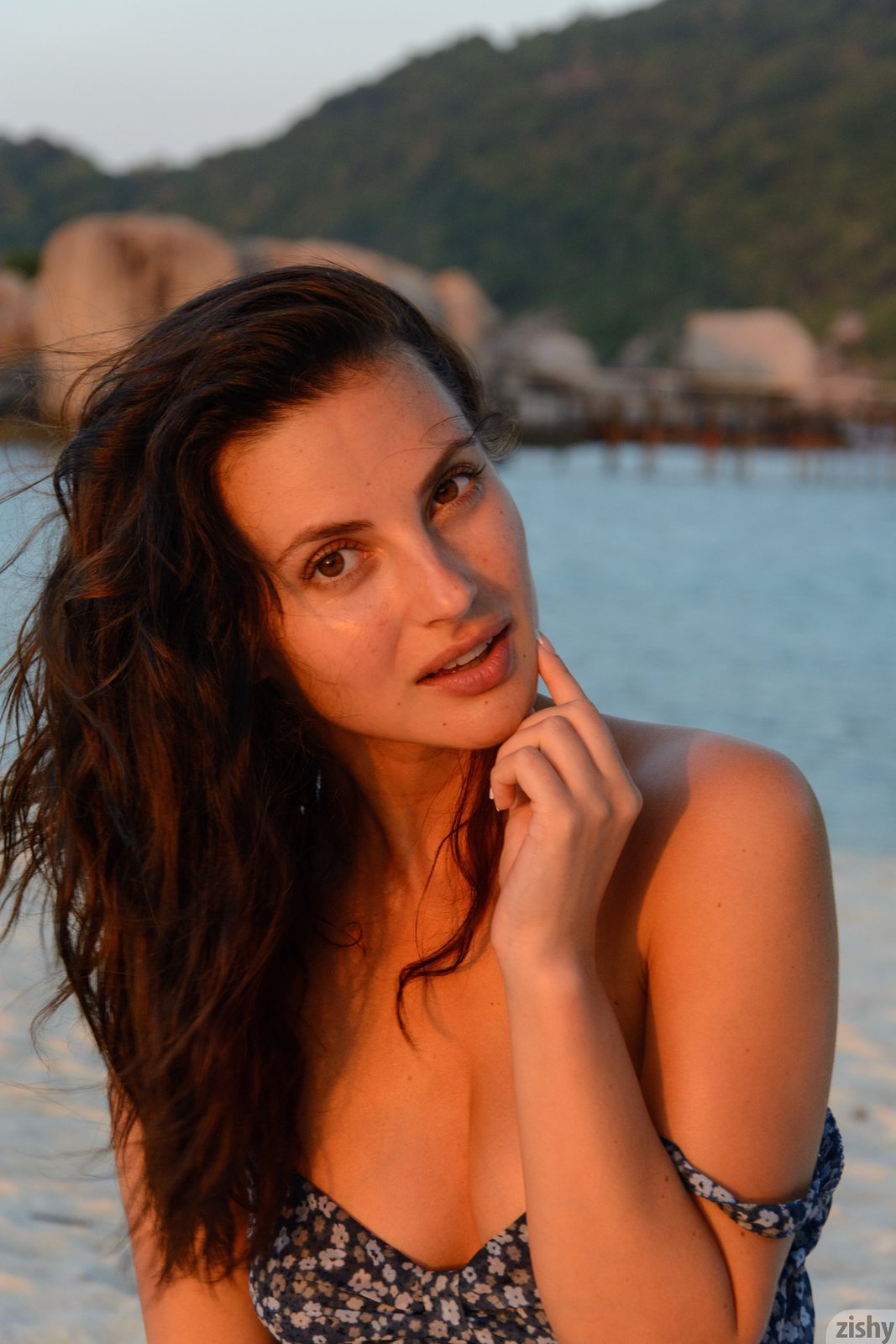 Сексапильная девушка в купальнике нежится на пляже